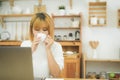 Beautiful young smiling woman working on laptop while enjoying drinking warm coffee sitting in a living room at home. Royalty Free Stock Photo