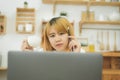 Beautiful young smiling woman working on laptop while enjoying drinking warm coffee sitting in a living room at home. Royalty Free Stock Photo