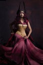 Beautiful young South Asian woman with red hair is dressed as a warrior princess
