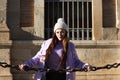 beautiful young spanish woman with woollen cap is leaning on the chains surrounding the cathedral of seville in spain. The woman Royalty Free Stock Photo