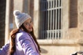 beautiful young spanish woman with woollen cap is leaning on the chains surrounding the cathedral of seville in spain. The woman Royalty Free Stock Photo