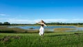 Beautiful young spiritual blonde woman long hair dancing and spinning in a field next to a lake white skirt Royalty Free Stock Photo