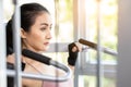 Beautiful young sport woman exercising in gym by using Shoulder press machine Happy girl wear gloves and love exercise She has Royalty Free Stock Photo