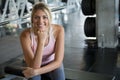 Beautiful young sport woman taking a break from exercise in fitness gym .girl in sportswear workout rest