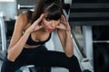 Beautiful young sport woman tired taking a break from exercise sitting on machine in fitness gym . girl in sportswear workout