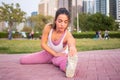 Beautiful young sportive woman stretching her legs outdoors Royalty Free Stock Photo