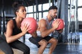 Beautiful young sports couple is working out with medicine ball in gym Royalty Free Stock Photo
