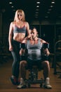 Beautiful young sporty couple showing muscle and workout in gym dumbbell Royalty Free Stock Photo