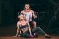 Beautiful young sporty couple showing muscle and workout in gym dumbbell Royalty Free Stock Photo