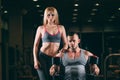 Beautiful young sporty couple showing muscle and workout in gym dumbbell Royalty Free Stock Photo