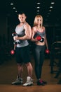 Beautiful young sporty couple showing muscle and workout in gym dumbbell Royalty Free Stock Photo