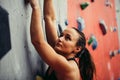 Beautiful young strong woman climbing on red artificial wall top view. Royalty Free Stock Photo