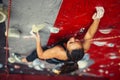 Beautiful young strong woman climbing on red artificial wall top view. Royalty Free Stock Photo