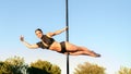 Beautiful young strong woman making a pose on a pole Royalty Free Stock Photo