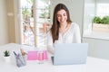 Beautiful young student woman studying for university using laptop and notebook with a happy face standing and smiling with a Royalty Free Stock Photo