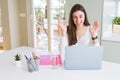 Beautiful young student woman studying for university using laptop and notebook very happy and excited, winner expression Royalty Free Stock Photo