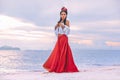 Beautiful young stylish boho woman walking on the beach at sunset Royalty Free Stock Photo