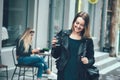 Beautiful young stylish casual woman wear in fashion clothes and staying on street and holding black cup of coffee Royalty Free Stock Photo