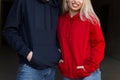 Beautiful young stylish couple in trendy hoodie indoors with sunshine. Hipster happy girl in red hoodie and handsome man Royalty Free Stock Photo