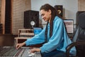 Stylish female audio engineer, producer works in music recording studio, uses mixing board, software to create cool song Royalty Free Stock Photo