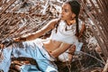 Beautiful young stylish woman at dry palm leaves backgground