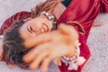 Beautiful young stylish woman in red dress lying on sand on the beach at sunset Royalty Free Stock Photo