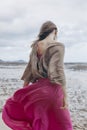 Beautiful young stylish woman in red skirt walking on the beach