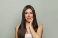 Beautiful young surprised brunette model woman with clear skin and long healthy straight hair on white background Royalty Free Stock Photo