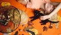 Beautiful young surprised woman in witches hat and costume holding pumpkin. Black cat with pretty girl. Beautiful young Royalty Free Stock Photo