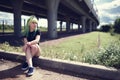 Beautiful young swag woman with green hair posing near highway road