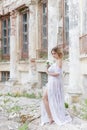 Beautiful young sweet blonde girl with wedding bouquet in the hands of the boudoir in a white dress with evening hairstyle walks Royalty Free Stock Photo