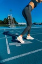 Beautiful young tanned woman, prepared and smiling with positive attitude to do a sprint running with her legs bent and in Royalty Free Stock Photo