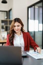 Beautiful young teen asian businesswoman using laptop computer and paperworks with planning working on financial Royalty Free Stock Photo