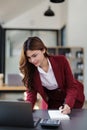 Beautiful young teen asian businesswoman using laptop computer and paperworks with planning working on financial Royalty Free Stock Photo