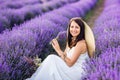 Beautiful woman in a white dress and hat collects lavender. Summer photos Royalty Free Stock Photo