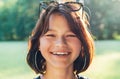 A beautiful young teenage girl cheerfully smiling at the camera with a warm sunset backlight bokeh. Beautiful people and a fashion