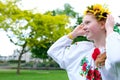 beautiful young teenage girl in wreath for Ukrainian holiday with friend communicate tradition put a wreath on her head Royalty Free Stock Photo