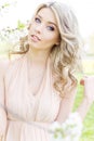 Beautiful young tender sweet girl flying in a light dress walking in a lush cherry orchard Royalty Free Stock Photo