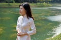 Beautiful young thoughtful Asian woman  standing at the river bank Royalty Free Stock Photo