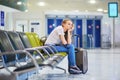 Beautiful young tourist girl with backpack and carry on luggage in international airport Royalty Free Stock Photo