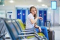 Beautiful young tourist girl with backpack and carry on luggage in international airport Royalty Free Stock Photo