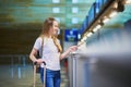 Beautiful young tourist girl in international airport at check-in counter Royalty Free Stock Photo