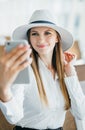 Beautiful young tourist girl in international airport, taking funny selfie with passport and boarding pass near flight Royalty Free Stock Photo