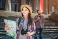 Beautiful young tourist stand in front and look forward. She smiles. Young woman holds map in one hand and binoculars in Royalty Free Stock Photo