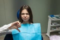 Beautiful young upset brunette patient woman having examination at dental office showing dislike sign, looking unhappy, healthcare