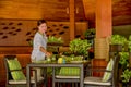 Beautiful young waitress serving table in the restaurant