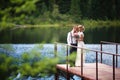 Beautiful young wedding couple, bride and groom posing on lake background. The groom and the bride on pier.