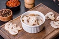 Beautiful young white champignons torn to slices on a dark concrete background Royalty Free Stock Photo