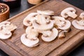 Beautiful young white champignons torn to slices on a dark concrete background Royalty Free Stock Photo