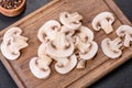 Beautiful young white champignons torn to slices on a dark concrete background Royalty Free Stock Photo